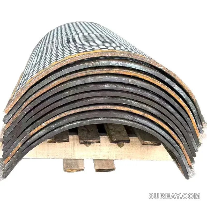 Stack of curved shredder screen plates on a pallet, showing staggered round hole pattern